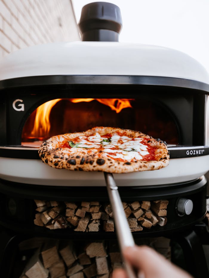 Freshly baked Neapolitan pizza in a wood-fired oven in London. Perfectly charred crust.